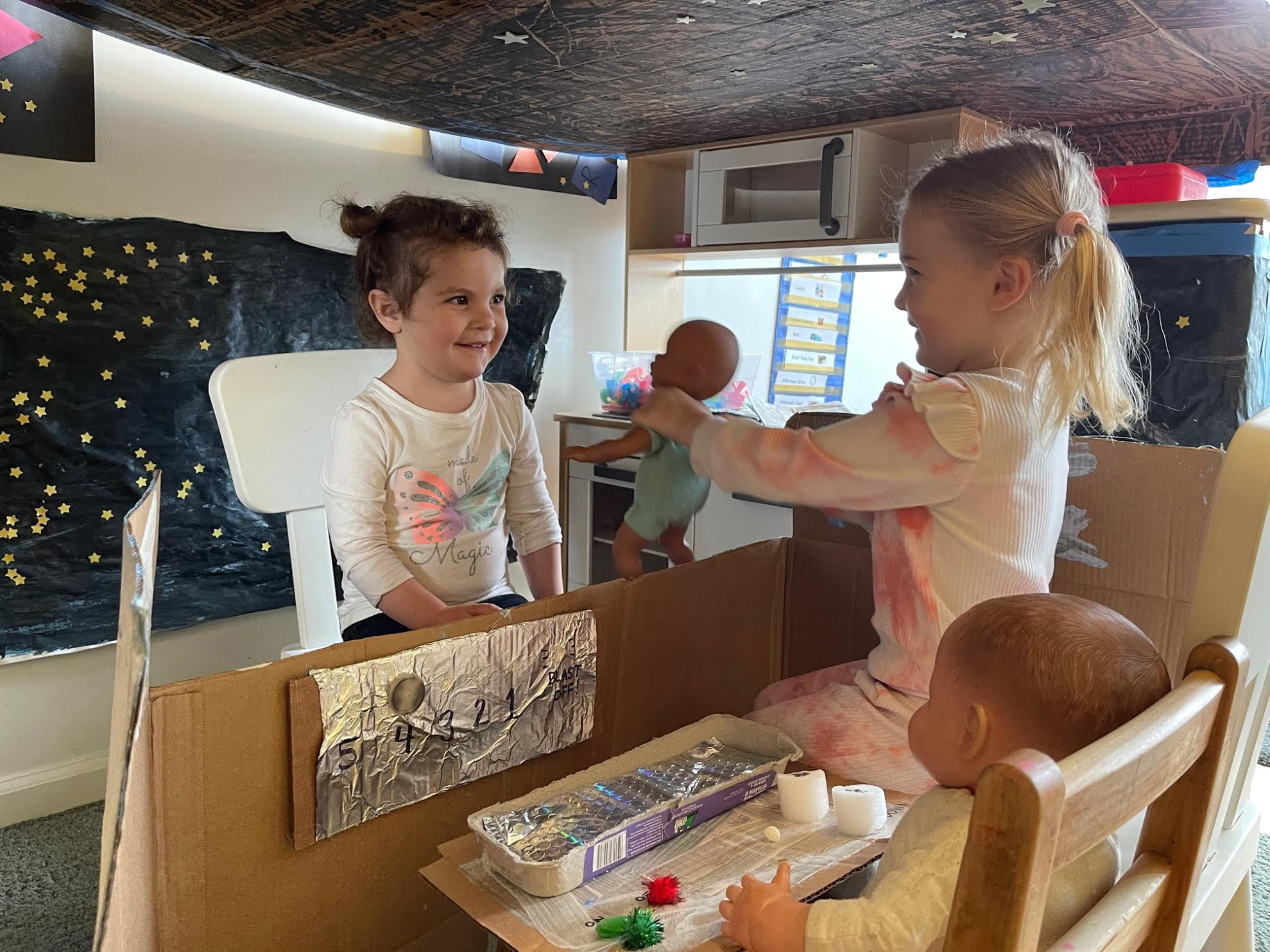 Young children playing house with play set.